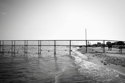 Swimming pool by sea against clear sky