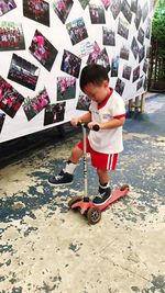 Boy riding push scooter on road