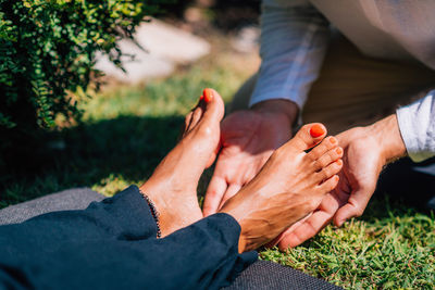 Hands of a reiki therapist healing and balancing energy points in feet. energy healing concept