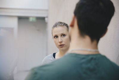 Female computer programmer discussing with male colleague in office