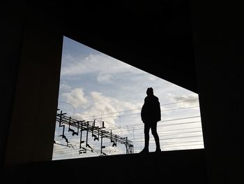 Low angle view of silhouette people standing against sky