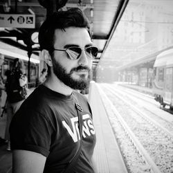 Young man wearing sunglasses at railroad station