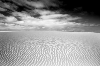 Scenic view of sand at beach against sky