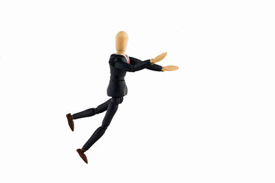 Low angle view of figurine on wood against white background