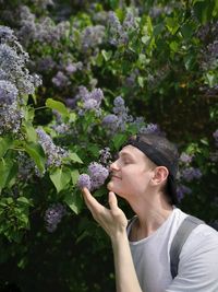 Young woman holding purple flowering plant