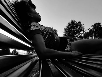 Side view of boy sitting on railing