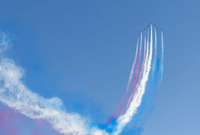 Low angle view of airplane flying against blue sky