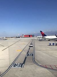 Airplane on airport runway against clear blue sky