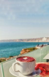 Close-up of coffee on sea against sky