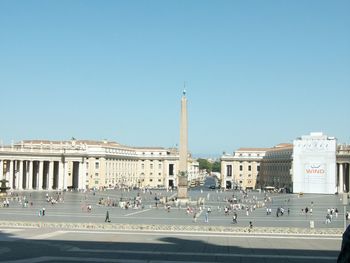 View of buildings in city against clear blue sky