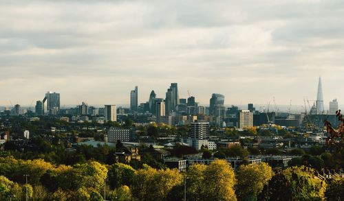 Buildings in city against cloudy sky