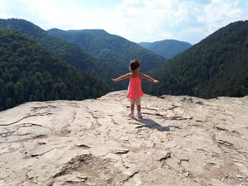 Full length of girl standing on mountain against sky