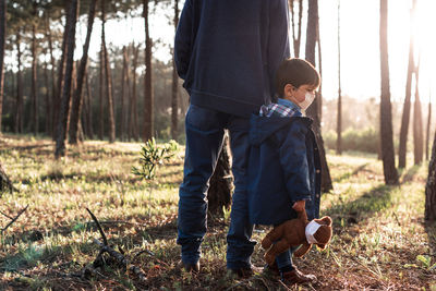 Father and son standing on land in forest