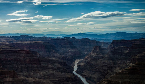 Scenic view of mountain range against cloudy sky