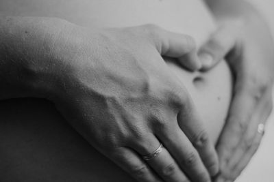 Midsection of pregnant woman touching her belly