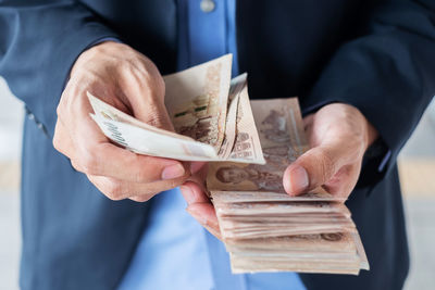 Midsection of businessman counting money