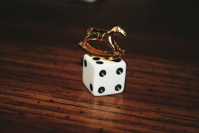 Close-up of dice with toy on wooden table