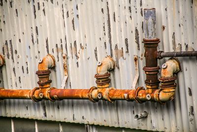 Close-up of rusty pipes on metal wall