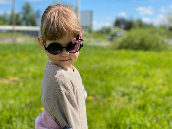 Portrait of boy wearing sunglasses on field