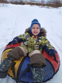 Full length of boy standing on snow covered field