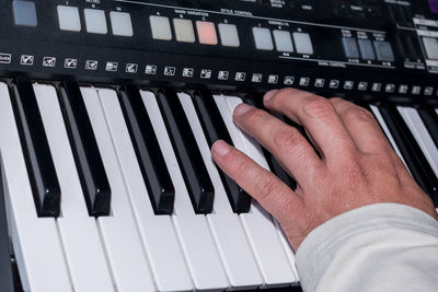 Cropped hand of man playing piano
