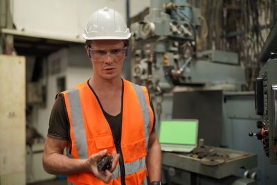 Portrait of man standing in factory