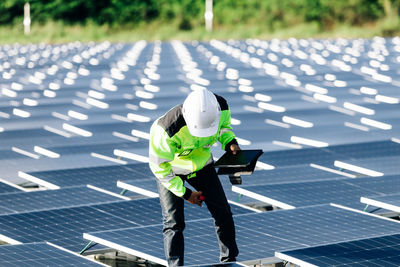 Technical expert in solar energy checks the productivity solar panel field for examination
