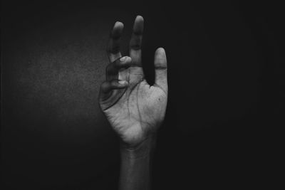 Close-up of human hand against black background