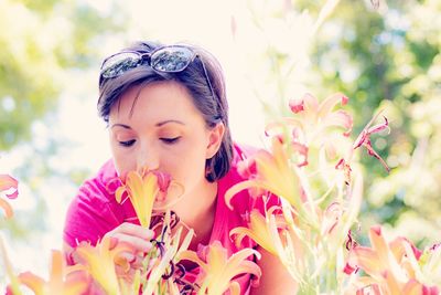 Portrait of woman with pink flowers against blurred background