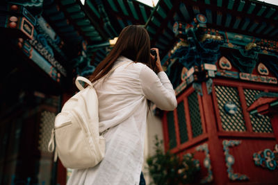 Rear view of woman standing outside building