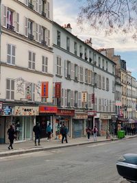 People walking on street against buildings in city