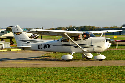 Airplane on airport runway against sky