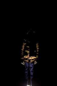 Full length of man standing against black background