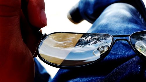 Close-up of man photographing on side-view mirror