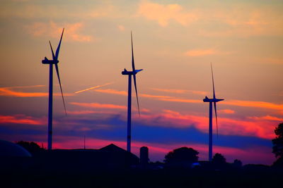 Scenic view of evening sky with three windmill silhouettes during sunset