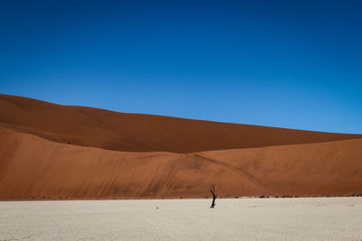 Scenic view of desert against clear blue sky