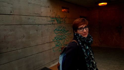 Portrait of woman standing against wall
