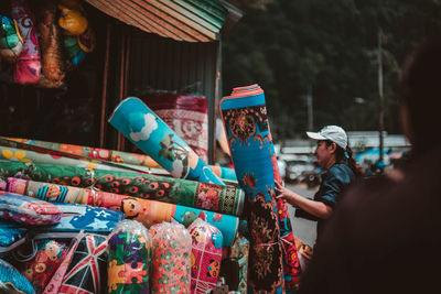 Woman choosing carpet at market stall