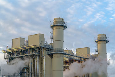 Low angle view of smoke stack against sky