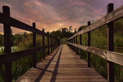 Footbridge over river at sunset