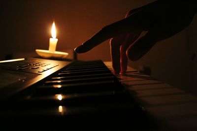 Close-up of lit candle in darkroom