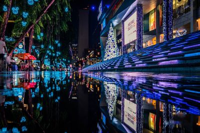 Reflection of illuminated buildings in puddle at night