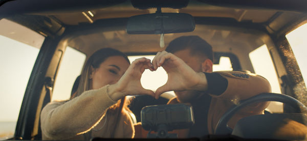 Happy boy and girl in the off road car during valentines day