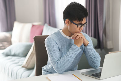 Man using mobile phone while sitting on table