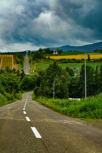 Empty road against cloudy sky