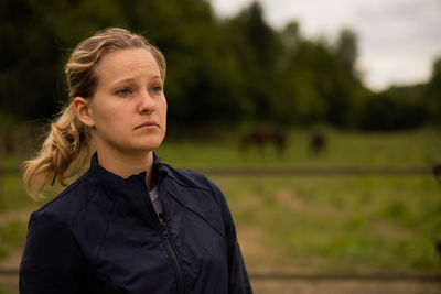 Portrait of a beautiful young woman standing on field