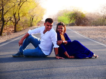 Young couple sitting on road