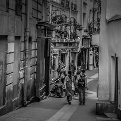 People walking on street amidst buildings in city