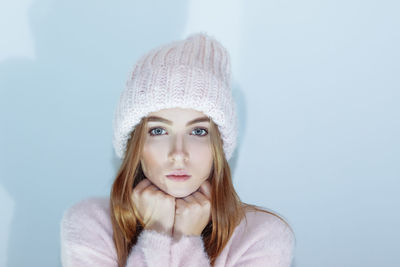Portrait of young woman against white background