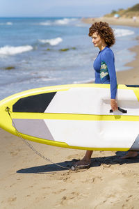 Rear view of woman in boat on beach